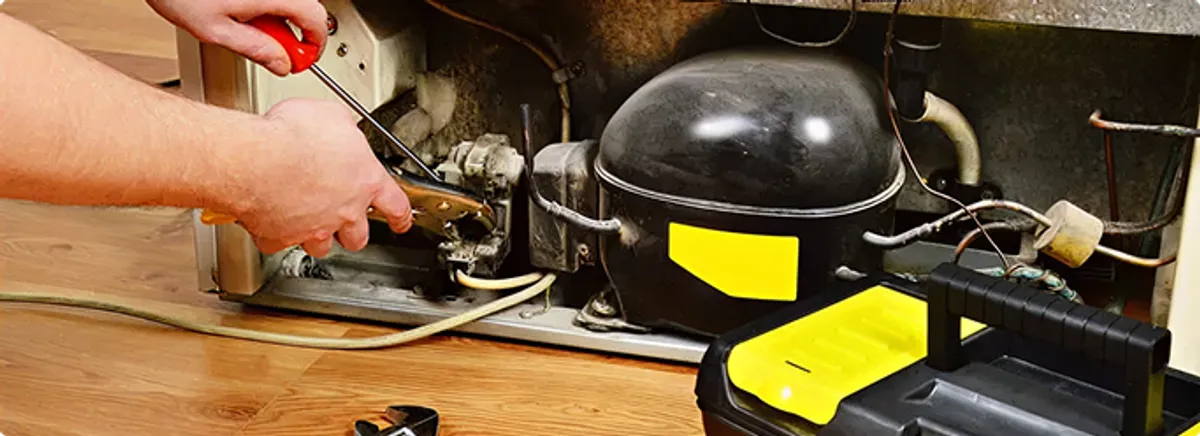 Refrigerator repair technician fixing the compressor and wiring in Bryceville, FL