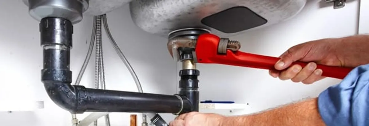 Garbage disposal repair technician tightening the sink drain and disposal connection in Jacksonville, FL