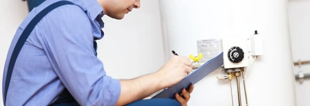 Water heater repair technician inspecting the unit and recording service notes in Jacksonville, FL